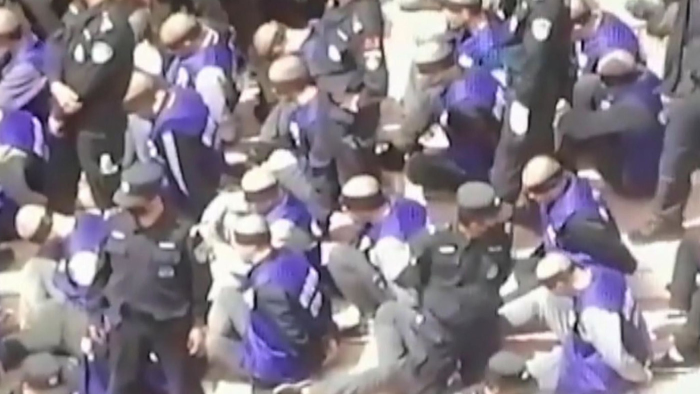 Screen grab of detainees in Xinjiang moved by Chinese forces.