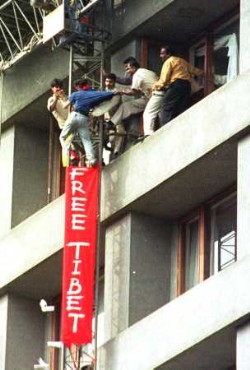 Tenzin Tsundue is caught by security while releasing a "Free Tibet" banner, on the 8th floor of the Oberoi Hotel where Chinese Premier Zhu Rongji was addressing a business meeting in Bombay, India, Wednesday, Jan. 16, 2002