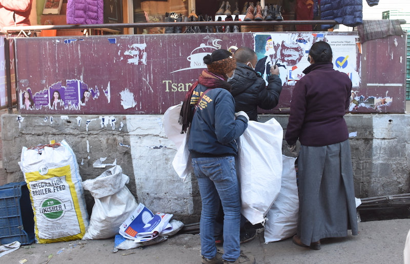 Staffs of the regional Election Commission in Dharamshala removing camapign posters from the streets on Dec. 31, 2020 (Phayul photo by Kunsang Gashon)
